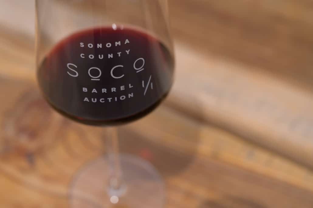 Red wine in a Sonoma County Barrel Auction glass on a wooden counter